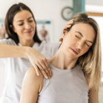 Young woman at physical therapy program feeling neck pain